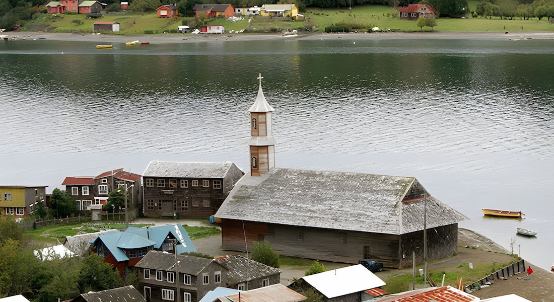 Paisaje típico de Chiloé con iglesia de madera y entorno costero